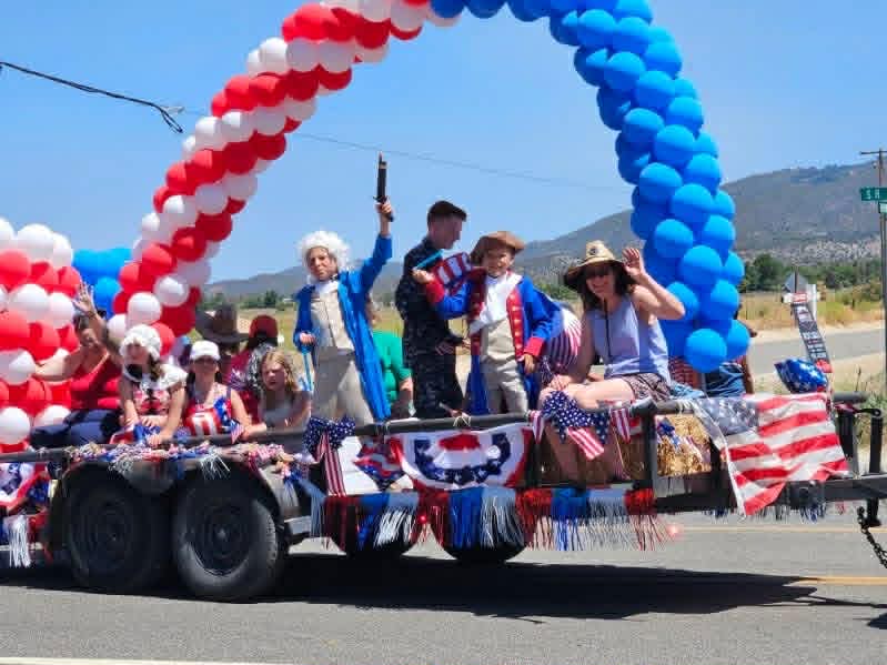 Patriotic float with balloon arch and historical costumes