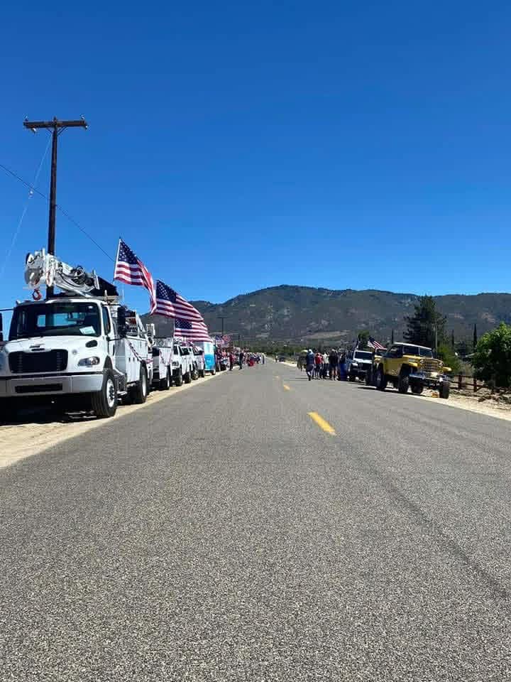 Long lineup of utility trucks and vehicles for the parade on the highway